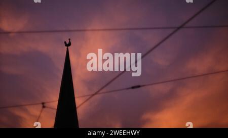 Brunswick, Germania. 2 novembre 2023. Le nuvole si tingono di rosa dalla luce del sole nascente, con il campanile di San La Chiesa evangelica luterana di Peter e il suo rubinetto antistante. Crediti: Stefan Jaitner/dpa/Alamy Live News Foto Stock