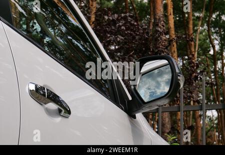 Vista dal basso dello specchio per auto con riflesso delle nuvole Foto Stock