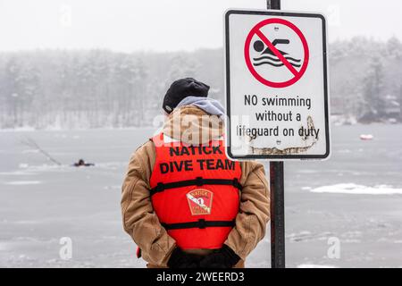 Durante l'addestramento di soccorso su ghiaccio al White Pond di Concord, un membro del District 14 Dive Team si trova accanto alla firma, No Swimming senza un bagnino in servizio. Foto Stock