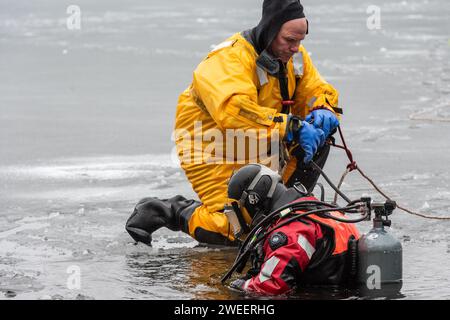 Vigili del fuoco e polizia con la squadra subacquea del Massachusetts District 14, che conduce un addestramento di soccorso su ghiaccio a White Pond a Concord. Foto Stock