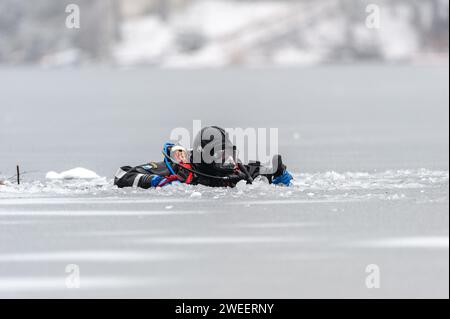 Vigili del fuoco e polizia con la squadra subacquea del Massachusetts District 14, che conduce un addestramento di soccorso su ghiaccio a White Pond a Concord. Foto Stock