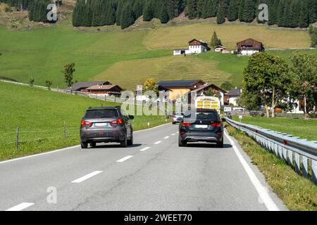 Tirolo, Italia - 23 settembre 2022: Un'auto sorpassa altri veicoli su una strada di campagna *** Ein Auto überholt andere Fahrzeuge auf einer Landstraße Foto Stock