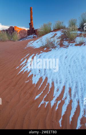 Il Totem Pole con neve e sabbia ondulata nel Monument Valley Navajo Tribal Park in Arizona. Foto Stock