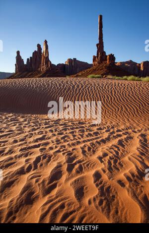 Totem Pole e Yei Bi Chei con sabbia ondulata nel Monument Valley Navajo Tribal Park in Arizona. Foto Stock