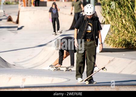 Eleganza da skate Park: Una skater donna scivola senza sforzo, dando vita a una dinamica scena di skate urbano. Foto Stock