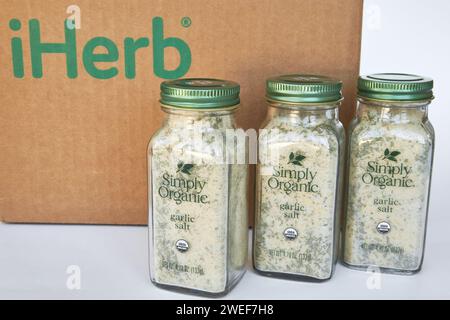 Tre vasetti di sale all'aglio e erbe aromatiche, marchio Simply Organic, spezie aromatiche. Scatola di cartone con logo iHerb, acquisti online. Comprare prodotti in un onli Foto Stock