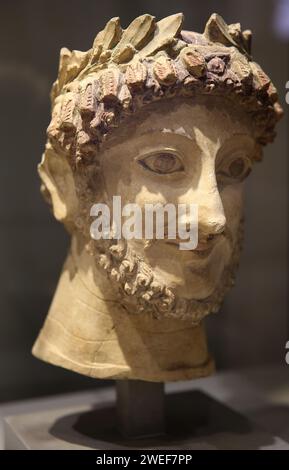 Scultura con tracce policrome. Testa con una corona di alloro di un prete Afrodite. ca. 500 a.C., da Athienous, isola di Cipro. Museo Barracco. Roma. Foto Stock