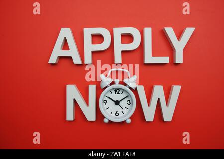 Applica ora lettere alfabetiche su sfondo rosso Foto Stock