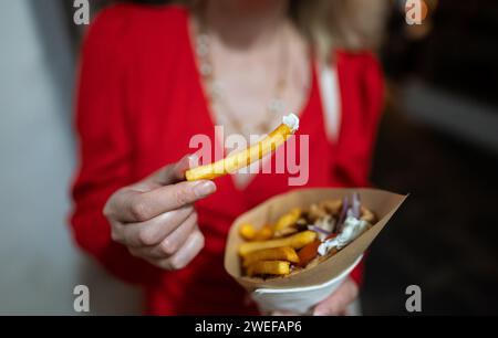 Donna mangia pita con patatine fritte. Foto Stock