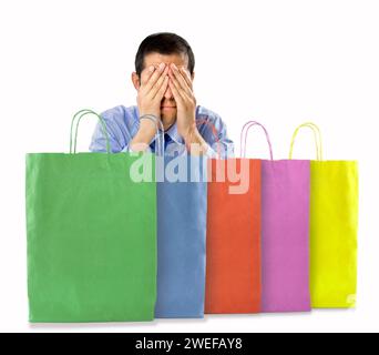 Uomo di shopping preoccupato dopo acquisti multipli con sfondo bianco Foto Stock