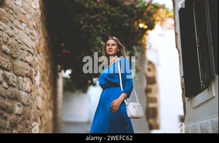 Turista femminile in abito blu per la strada di Lindos in Grecia. Foto Stock