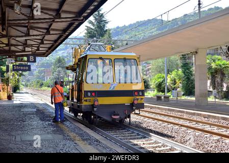 Un veicolo per la manutenzione dei binari Trenitalia si ferma alla stazione di Stresa per prelevare il personale. Foto Stock