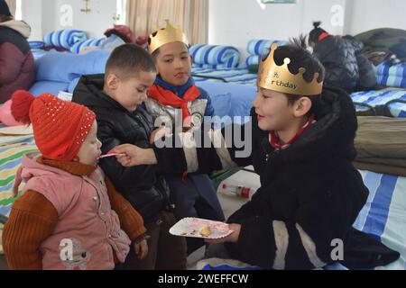 Wushi, regione autonoma cinese di Xinjiang Uygur. 25 gennaio 2024. I bambini condividono torte di compleanno in un sito di reinsediamento nella contea di Wushi, nella regione autonoma di Xinjiang Uygur, nella Cina nord-occidentale, 25 gennaio 2024. I bambini si sono divertiti a condividere le torte di compleanno donate da persone care in un sito di reinsediamento nella contea di Wushi giovedì. Un terremoto di magnitudo 7,1 ha colpito la contea di Wushi nella prefettura di Aksu, nella regione autonoma Xinjiang Uygur della Cina nord-occidentale alle 2:09 di martedì (ora di Pechino), secondo il China Earthquake Networks Center (CENC). Crediti: GU Yu/Xinhua/Alamy Live News Foto Stock