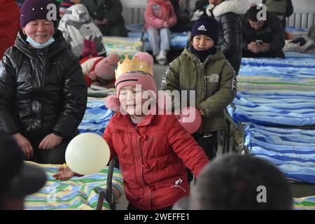 Wushi, regione autonoma cinese di Xinjiang Uygur. 25 gennaio 2024. I bambini giocano in un sito di reinsediamento nella contea di Wushi, nella regione autonoma Xinjiang Uygur della Cina nord-occidentale, 25 gennaio 2024. I bambini si sono divertiti a condividere le torte di compleanno donate da persone care in un sito di reinsediamento nella contea di Wushi giovedì. Un terremoto di magnitudo 7,1 ha colpito la contea di Wushi nella prefettura di Aksu, nella regione autonoma Xinjiang Uygur della Cina nord-occidentale alle 2:09 di martedì (ora di Pechino), secondo il China Earthquake Networks Center (CENC). Crediti: Su Chuanyi/Xinhua/Alamy Live News Foto Stock