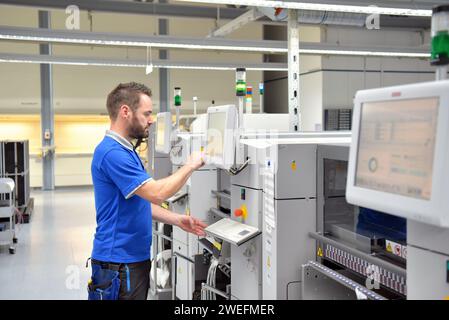 In ingegneria microelettronica: i lavoratori nella produzione e assemblaggio di electronic high tech componenti in un moderno stabilimento Foto Stock