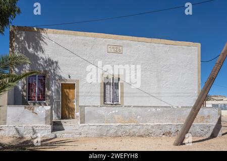 Paesaggio urbano con pittoresco edificio vecchio e semplice nel villaggio del deserto , girato con una luce brillante in tarda primavera ad Aus, Namibia, Africa Foto Stock