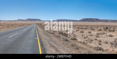 Paesaggio con strada di catrame B4 nel deserto, girato in tarda primavera a ovest di Goageb, Namibia, Africa Foto Stock