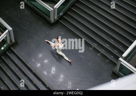 sopra la vista di una donna che pratica yoga sulle scale Foto Stock
