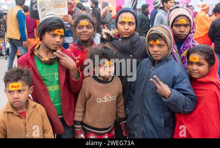 Ai bambini viene dipinto il nome di Lord RAM sulla fronte, alla vigilia della cerimonia di consacrazione del tempio RAM, ad Ayodhya, Uttar Pradesh, India, il 22 gennaio 2024. Foto Stock