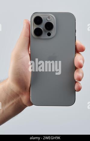 New York, USA - 25 gennaio 2024: Primo piano di iPhone 15 pro max in mano isolato su sfondo bianco dello studio Foto Stock