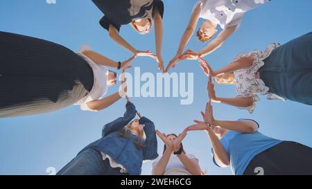 I bambini delle scuole fanno una forma di cuore dalle loro mani. Foto Stock