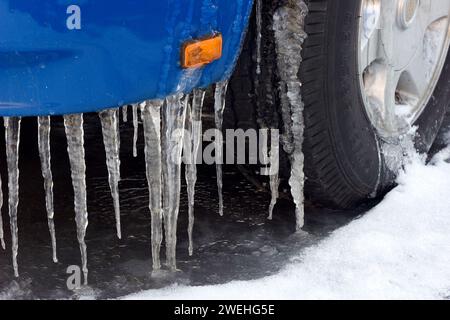 sono riconoscibili i lunghi ghiacci su un'auto blu, il simbolo della pioggia ghiacciata, i primi piani, il parafango e la ruota anteriore Foto Stock