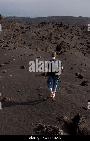 Una passeggiata turistica a piedi nudi sulla sabbia vulcanica presso il monumento naturale Los Volcanes de Teneguía, la Palma, Isole Canarie, Spagna Foto Stock