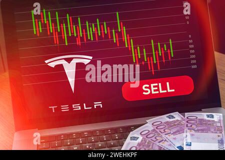 25 gennaio 2024: Computer portatile con tabella delle scorte sul segnale rosso di vendita accanto al logo TESLA del produttore di auto. Immagine simbolica per lo schianto e le perdite dello stock FOTOMONTAGE *** laptop computer mit Aktien Chart auf rotem Verkaufen Signal neben Autohersteller TESLA Logo. Symbolbild für den Crash und Verluste der Aktie FOTOMONTAGE Foto Stock