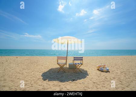 Sdraio e ombrellone perfettamente posizionati su una spiaggia tranquilla invitano al relax, catturando l'essenza della serenità del mare e la promessa di una tranquilla esca Foto Stock