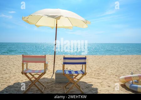 Sdraio e ombrellone perfettamente posizionati su una spiaggia tranquilla invitano al relax, catturando l'essenza della serenità del mare e la promessa di una tranquilla esca Foto Stock