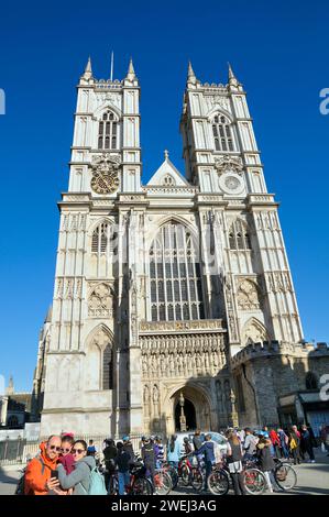 I turisti visitano l'ingresso della Great West Door sotto i campanili della facciata occidentale dell'Abbazia di Westminster nel centro di Londra, Inghilterra, Regno Unito Foto Stock