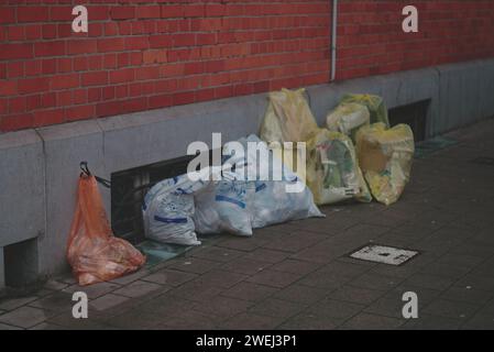 Sacchi per rifiuti sul marciapiede in Belgio. Bruxelles spazzatura. La spazzatura viene raccolta nei sacchetti mostrati nella foto. L'ordinamento avviene in pacchetti diversi Foto Stock