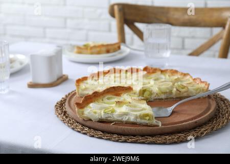 Tavola con gustosa torta di porri e torta sul tavolo Foto Stock