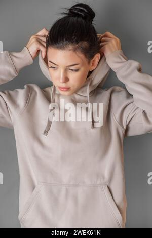 Teenager premurosa che indossa felpa con cappuccio Foto Stock