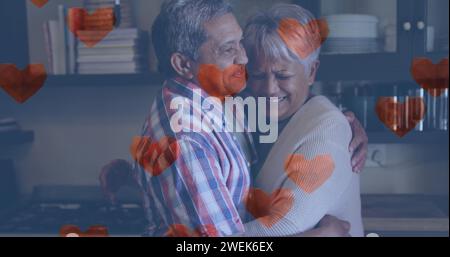 Più icone del cuore che fluttuano contro coppie afro-americane che si abbracciano a casa Foto Stock