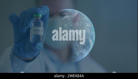 Immagine di globo che gira con lo scienziato che tiene il vaccino covid-19 che indossa maschere facciali Foto Stock