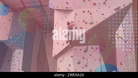 Forme colorate astratte contro l'arrampicata su muro di donna caucasica in palestra Foto Stock