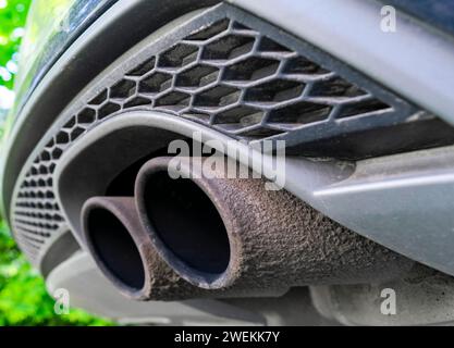 Primo piano del doppio tubo di scarico di un'auto. Doppi tubi di scarico di una moderna auto sportiva. Dettagli esterni dell'auto. Foto Stock