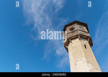 Acqua vecchia torre contro il cielo blu. Foto Stock