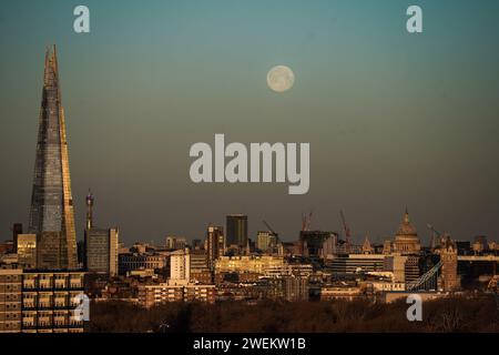 Londra, Regno Unito. 26 gennaio 2024. Tempo nel Regno Unito: La luna piena di lupi tramonta sulla città alla luce del sole del mattino. Crediti: Guy Corbishley/Alamy Live News Foto Stock