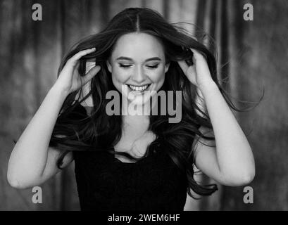 Bella modella giovane donna con capelli lunghi e un sorriso stupendo. bianco e nero Foto Stock