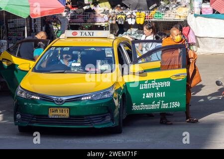 SAMUT PRAKAN, THAILANDIA, DEC 07 2023, Un monaco buddista scende da un taxi al mercato Foto Stock