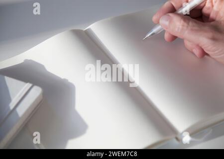 Uomo con una matita su una pagina vuota di un notebook Foto Stock