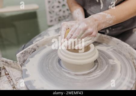 Primo piano di una donna che lavora alla ceramica alla ruota della ceramica in studio Foto Stock