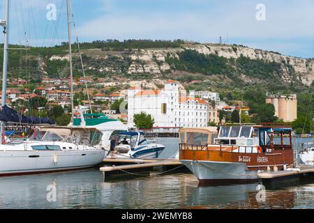 Una vista del porto con varie barche e una città costiera, Balchik, Balcik, Dobrich, Mar Nero, Bulgaria Foto Stock