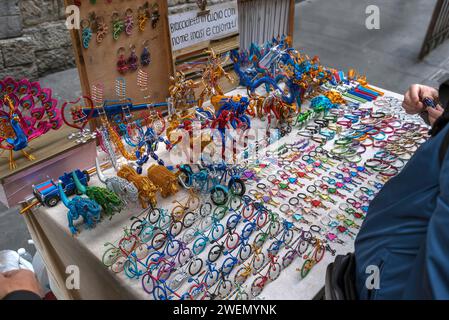 Tavolo con figure di filo colorato di un venditore ambulante, centro storico di Genova, Italia Foto Stock