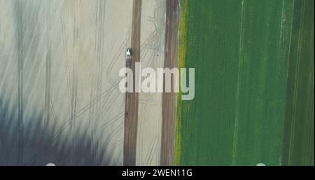 Trattore in funzione su campo di mietitura Foto Stock