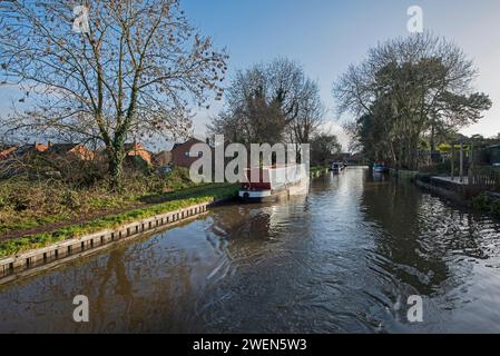 Vista da un narrowboat che viaggia nel paesaggio urbano inglese sul canale navigabile britannico con la barca ormeggiata Foto Stock