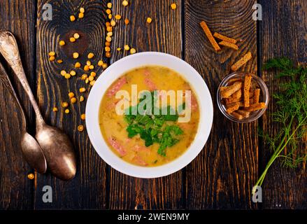 zuppa di piselli fresca in un recipiente con crostini Foto Stock