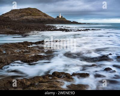 Il faro di Mumbles da Bracelet Bay. Foto Stock